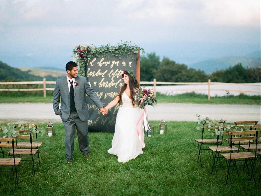Couple-Walking-Down-Isle-Caligraphy-Backdrop